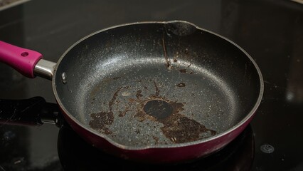 Used metal skillet showing wear and burn spots on the black surface