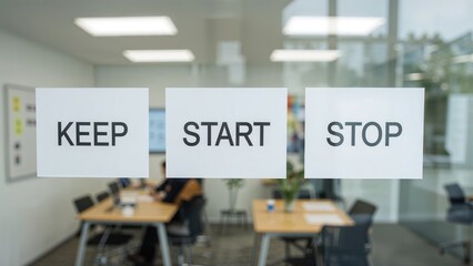 Three colorful Spanish labels reading keep, start, and stop are stuck on a window for a group working on a retrospective board with KISS and SCRUM techniques on an agile board.