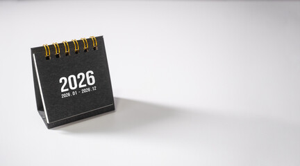 Black desk calendar on white table. 2026 calendar with copy space.