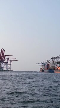 Container ships loading and discharging by shore crane in International Port of Tanjung Priok. Logistics and transportation of shipping, steve doring and lift on lift off at container yard. Jetty view