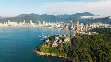 Aerial cityscape of Itapema with coastline, buildings, and surrounding mountains in Santa Catarina, Brazil.