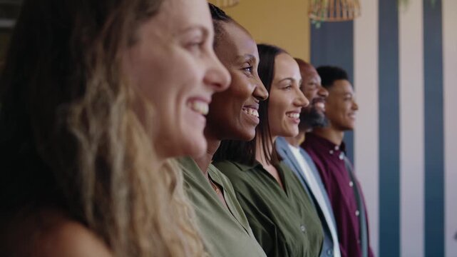 A diverse group of business people standing side by side in office during the daytime