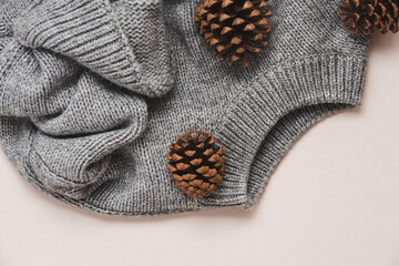 Cozy Gray Knit Sweater and Pine Cones on Beige Background. Autumn Winter Flat Lay