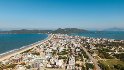 Fototapeta premium Aerial view of Mariscal and Canto Grande beaches with clear waters and coastal city, Santa Catarina, Brazil.