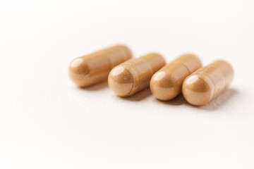 Ashwagandha (Withania somnifera) capsules. Concept for a healthy dietary supplementation. Bright paper background. Close up. Copy space.	