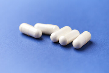 Creatine tablets on paper background. Soft focus. Close up. Copy space	