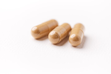 Ashwagandha (Withania somnifera) capsules. Concept for a healthy dietary supplementation. Bright paper background. Close up. Copy space.	