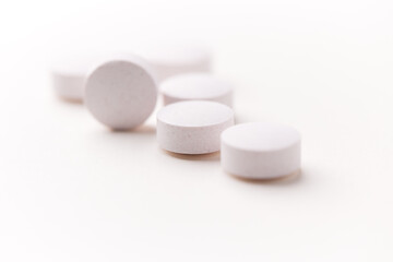 Creatine tablets on paper background. Soft focus. Close up. Copy space.	