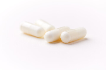 Creatine capsules on paper background. Soft focus. Close up. Copy space.	