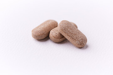 Ashwagandha (Withania somnifera) tablets on paper background. Soft focus. Close up. Copy space.	