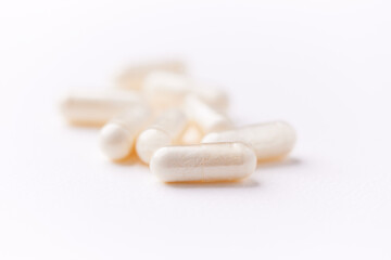 Coenzyme Q10 capsules. Antioxidants. Concept for a healthy dietary supplementation. Bright paper background. Soft focus. Close up. Copy space.	