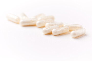 Coenzyme Q10 capsules. Antioxidants. Concept for a healthy dietary supplementation. Bright paper background. Soft focus. Close up. Copy space.	