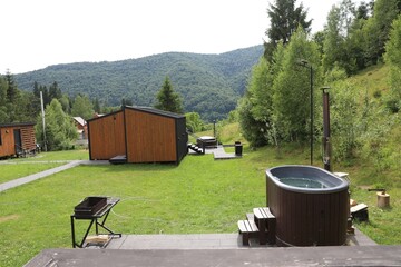 Tub with hot water and buildings at luxury resort in mountains