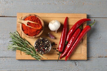 Different aromatic spices on grey wooden table, top view