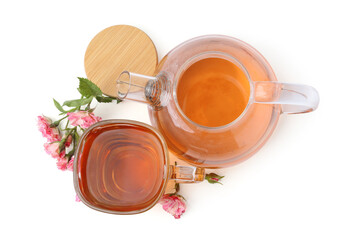 Tasty rose tea in glass cup, teapot and flowers isolated on white, top view