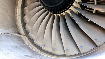 Close-up of aircraft engine fan blades, showcasing precision engineering, aerodynamic design, and...