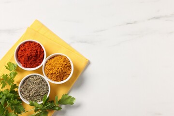 Different aromatic spices on white marble table, top view. Space for text