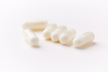 Creatine capsules on paper background. Soft focus. Close up. Copy space.	