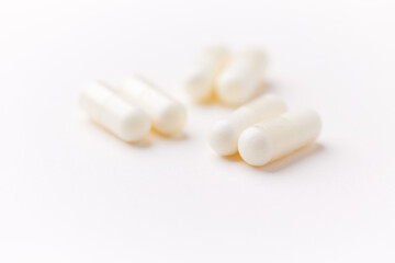 Creatine capsules on paper background. Soft focus. Close up. Copy space.	