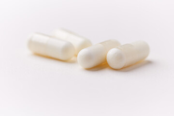 Creatine capsules on paper background. Soft focus. Close up. Copy space.	