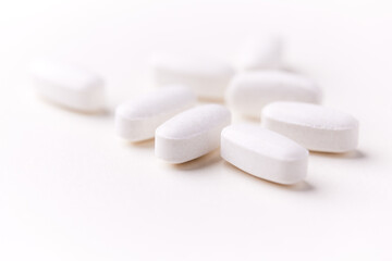 Creatine tablets on paper background. Soft focus. Close up. Copy space.	