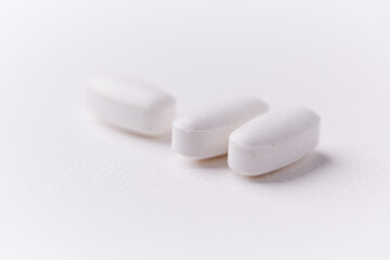 Creatine tablets on paper background. Soft focus. Close up. Copy space.	