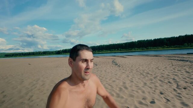 A guy stumbles while jogging on the beach and falls face first into the sand. A man fell into the sand during training and cleanses his face emotionally. An unpleasant incident. Slow motion.