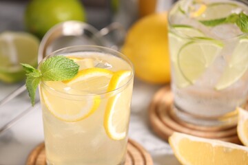 Tasty citrus cocktails with mint in glasses on table, closeup