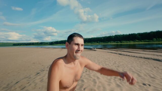 A man runs along the beach and unsuccessfully falls face first into the sand. A tanned guy in swimming trunks falls down on a run and emotionally cleanses his face of sand. Slow motion.