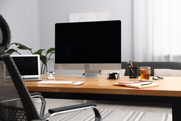 Stylish workplace with modern computer, other devices and stationery on wooden desk indoors