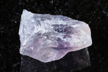 unworked purple striped fluorite mineral on black