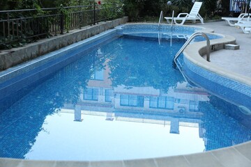 Outdoor swimming pool and different green plants, closeup