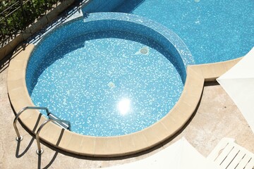 Beautiful outdoor swimming pool with ladder on sunny day, above view