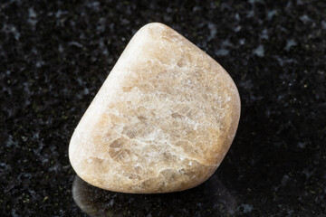 sample of polished cryolite rock on black granite