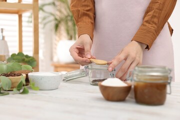 Woman making natural body scrub at white wooden table, closeup