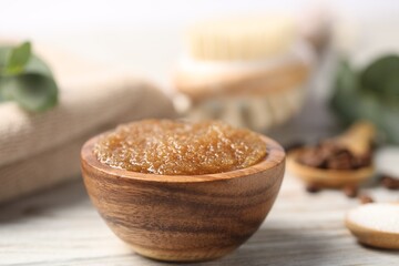 Natural body scrub in bowl on wooden table, closeup