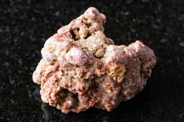 sample of raw chalcedony mineral on black granite