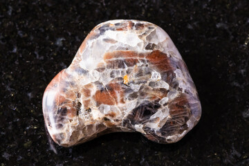 sample of polished monzonite mineral on black