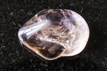 sample of tumbled ametrine mineral on black