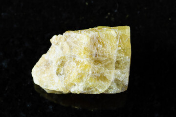 sample of raw yellow tourmaline mineral on black