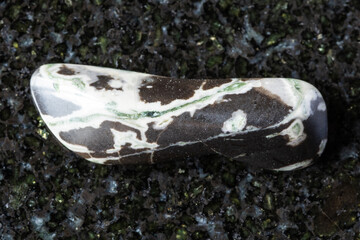 sample of tumbled hornfels mineral on black