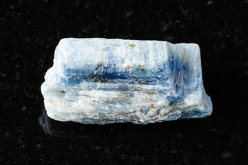 sample of rough kyanite rock on black granite