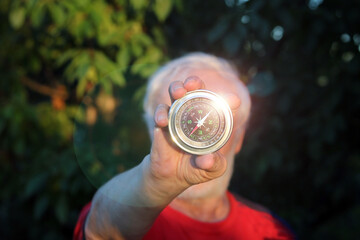 Classic shining compass in hand of man on natural background