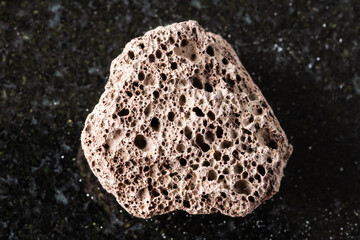 sample of rough brown pumice mineral on black