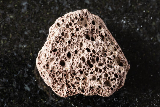 sample of rough brown pumice mineral on black