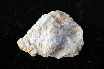 sample of raw xonotlite mineral on black granite
