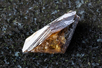 sample of raw twinned titanite crystal on black