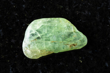 sample of tumbled green kyanite mineral on black