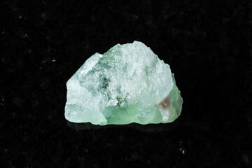 sample of raw herderite mineral on black granite