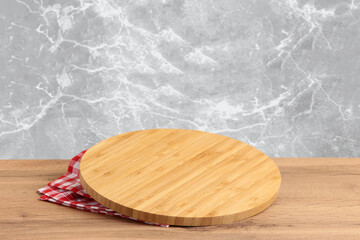 Round wooden board with red checked tablecloth on rustic wooden table kitchen cooking or baking...